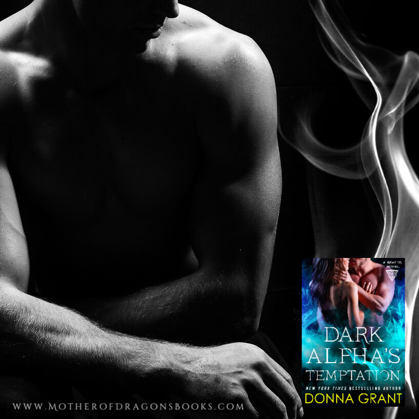 Male fitness model showing muscles in studio with a black background